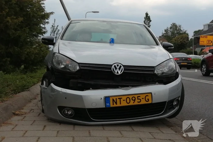 Auto botst op paal en krijgt klapband