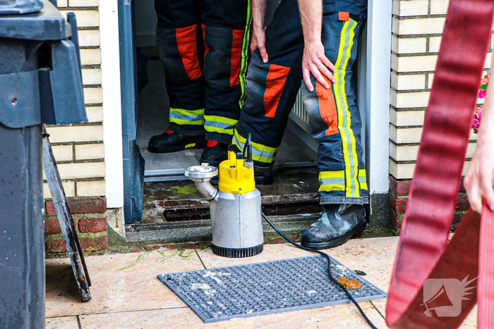 Brandweer helpt met leegpompen van onderwater gelopen woning