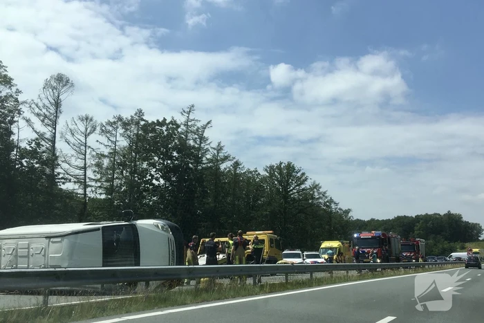 Bestelbus met aanhanger belandt op zijn kant