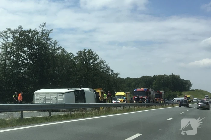 Bestelbus met aanhanger belandt op zijn kant