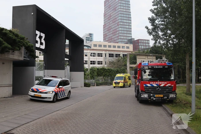 Man vast in hekwerk terrein kantoorgebouw