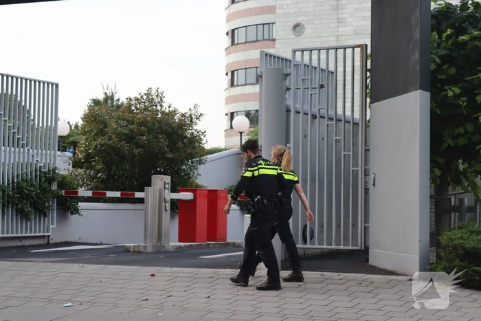 Man vast in hekwerk terrein kantoorgebouw