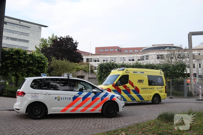 Man vast in hekwerk terrein kantoorgebouw