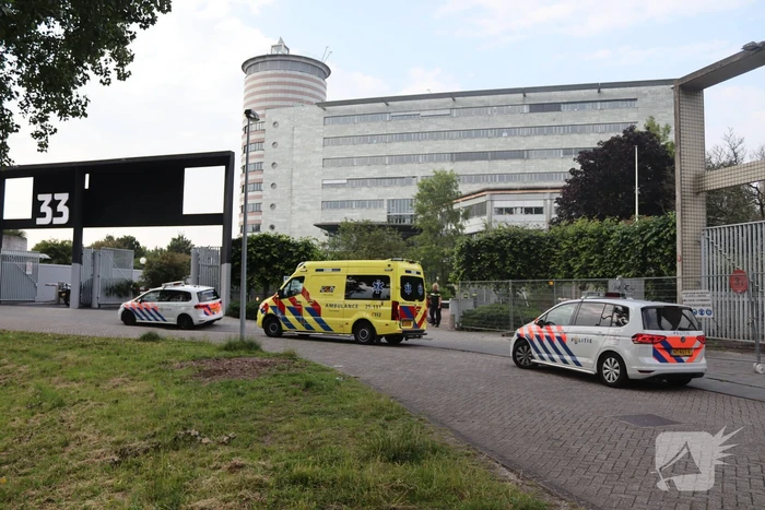 Man vast in hekwerk terrein kantoorgebouw