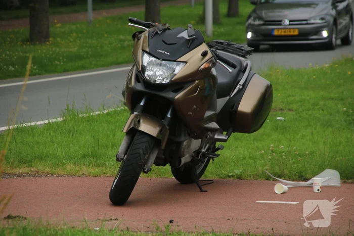 Motorfiets en auto botsen tegen elkaar