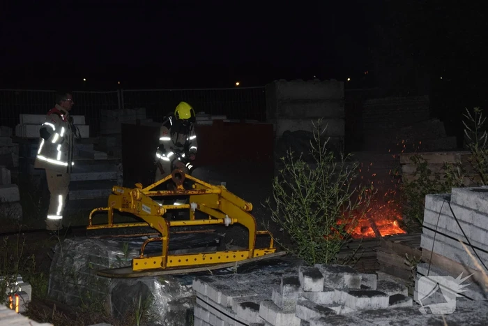 Brandstichting in stapel pallets op bouwterrein