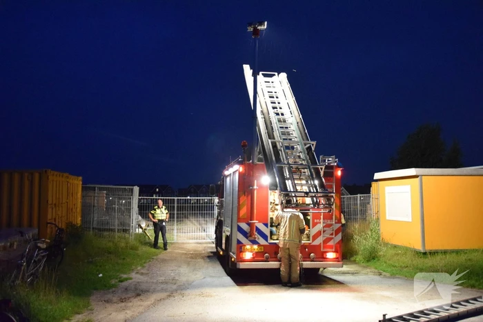 Brandstichting in stapel pallets op bouwterrein