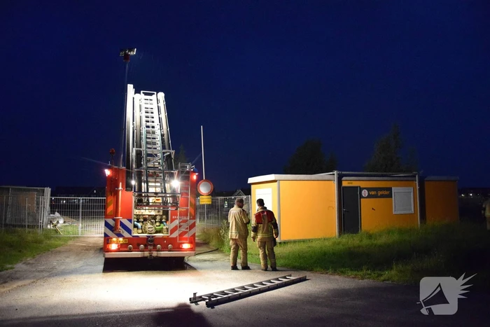 Brandstichting in stapel pallets op bouwterrein
