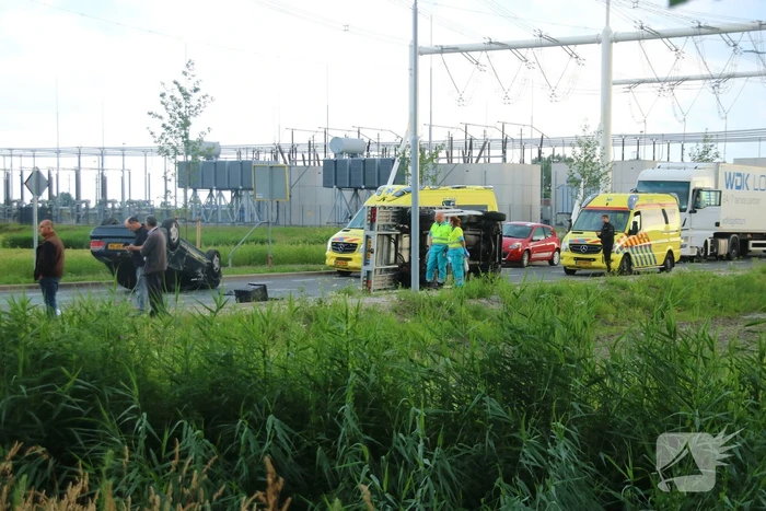 Autotransporter verliest auto en belandt op z'n kant na ongeval