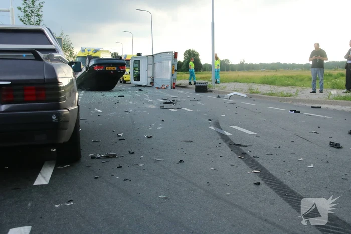 Autotransporter verliest auto en belandt op z'n kant na ongeval