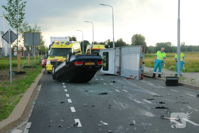 Autotransporter verliest auto en belandt op z'n kant na ongeval