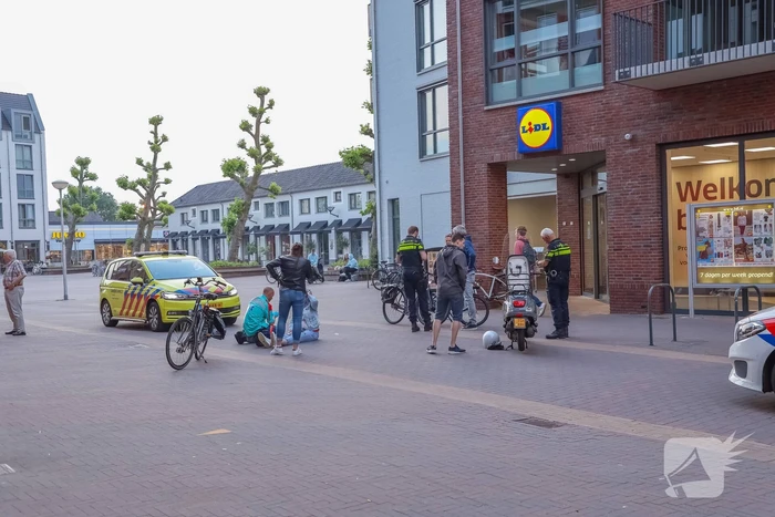 Fietsster gewond bij botsing met brommerrijder in winkelgebied