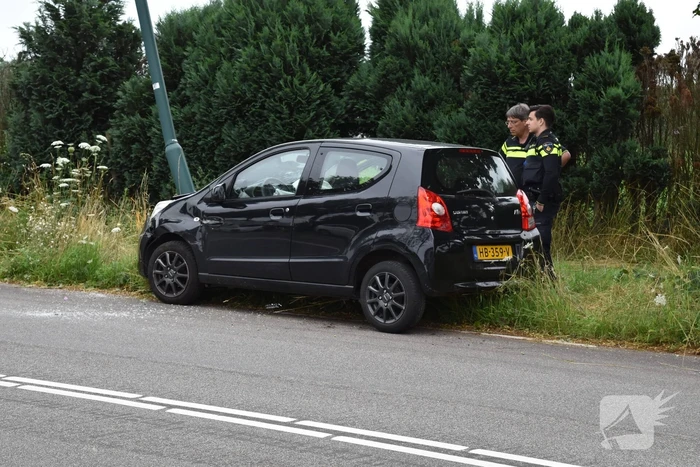 Automobilist parkeert auto tegen lantaarnpaal