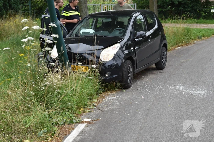 Automobilist parkeert auto tegen lantaarnpaal