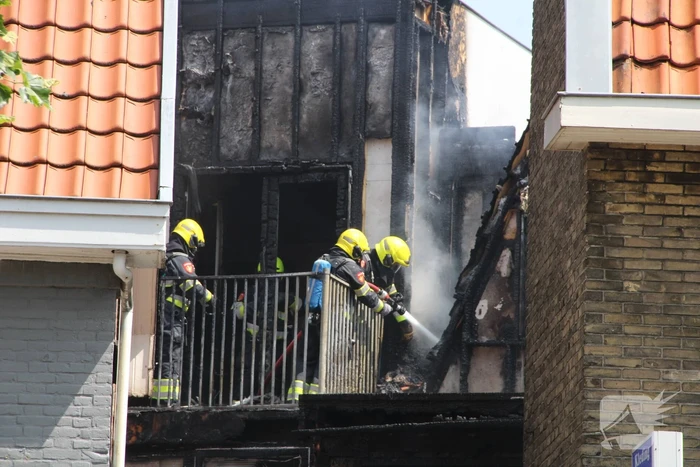Zwarte rookwolken bij grote uitslaande woningbrand