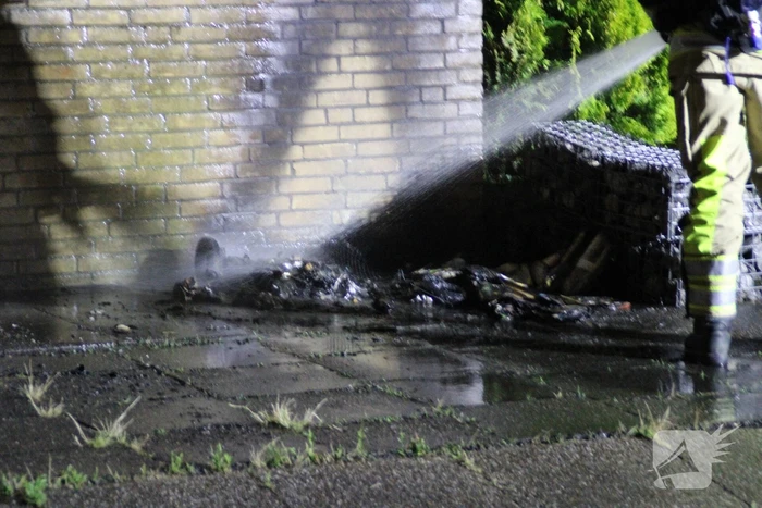 Schade aan muur door brandende papiercontainer