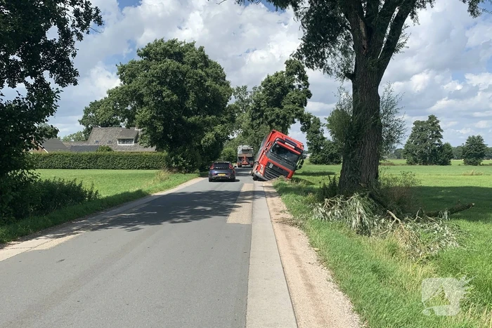Vrachtwagen met oplegger komt vast te zitten in greppel
