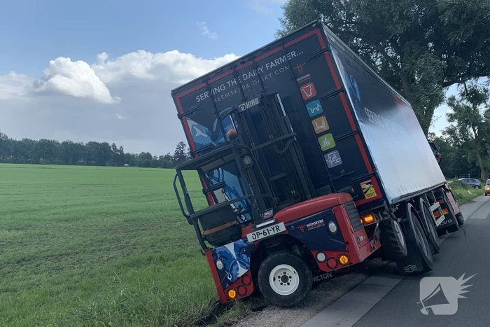 Vrachtwagen met oplegger komt vast te zitten in greppel