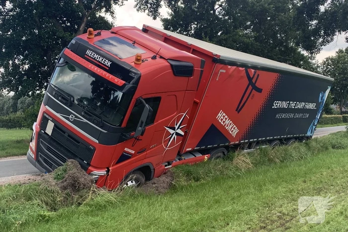 Vrachtwagen met oplegger komt vast te zitten in greppel