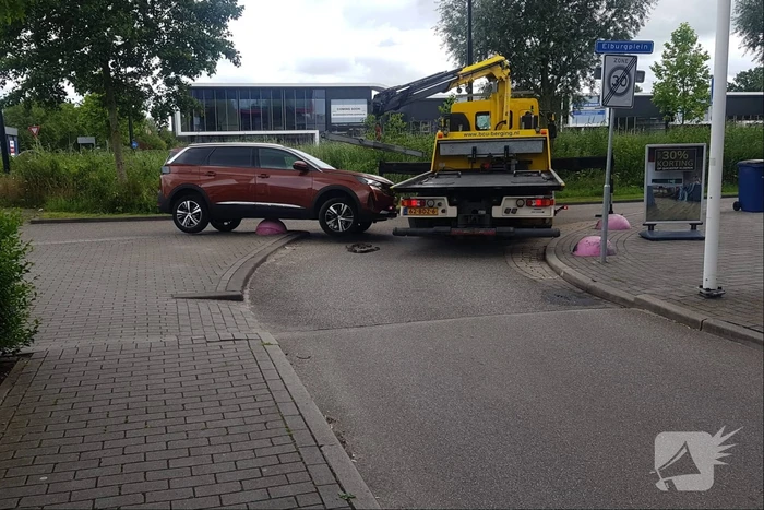 Auto belandt op betonnen sierbol