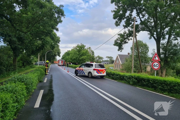 Bezorgauto slaat over de kop en ramt stroommast