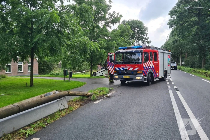 Bezorgauto slaat over de kop en ramt stroommast