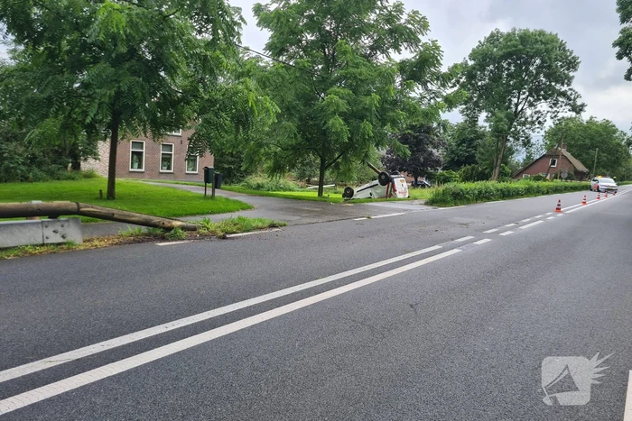 Bezorgauto slaat over de kop en ramt stroommast
