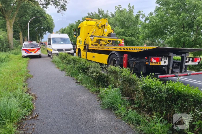 Bezorgauto slaat over de kop en ramt stroommast