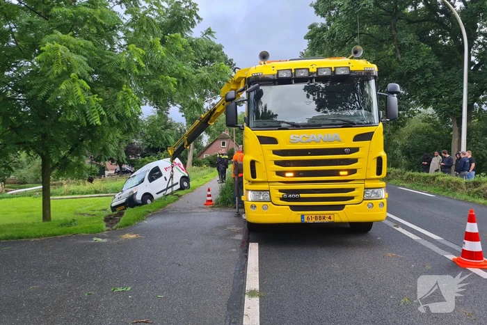 Bezorgauto slaat over de kop en ramt stroommast