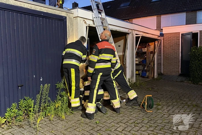 Kat vast tussen twee garageboxen