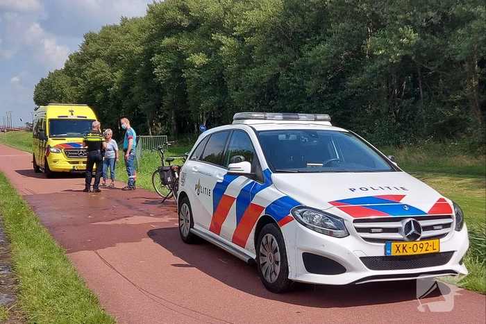 Vrouw rijdt met fiets sloot in