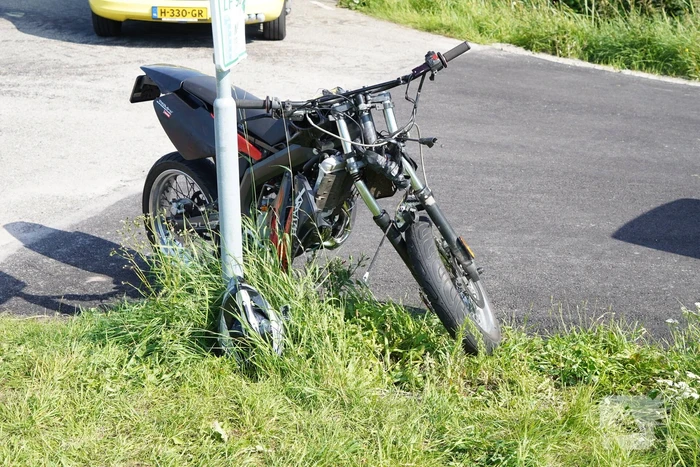 Bestuurder crossbrommer botst op geparkeerde auto