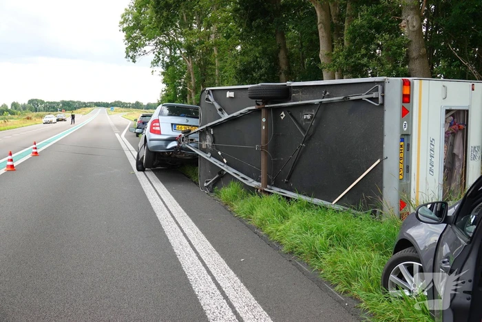 Auto met caravan belandt op zijn kant