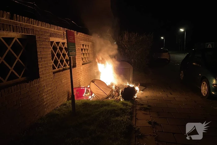 Brandweer blust brand bij container
