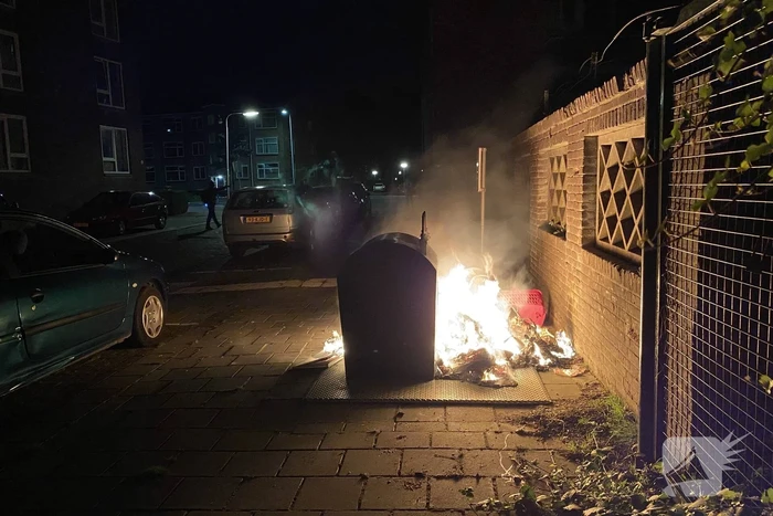 Brandweer blust brand bij container