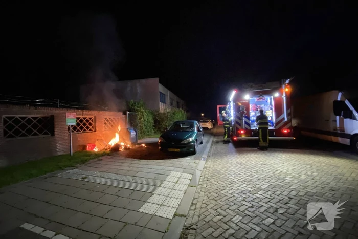 Brandweer blust brand bij container