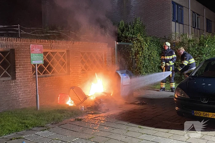 Brandweer blust brand bij container