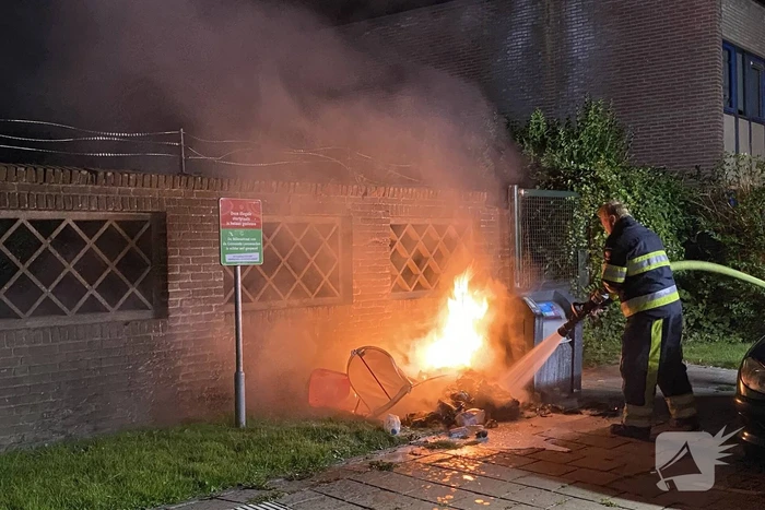 Brandweer blust brand bij container