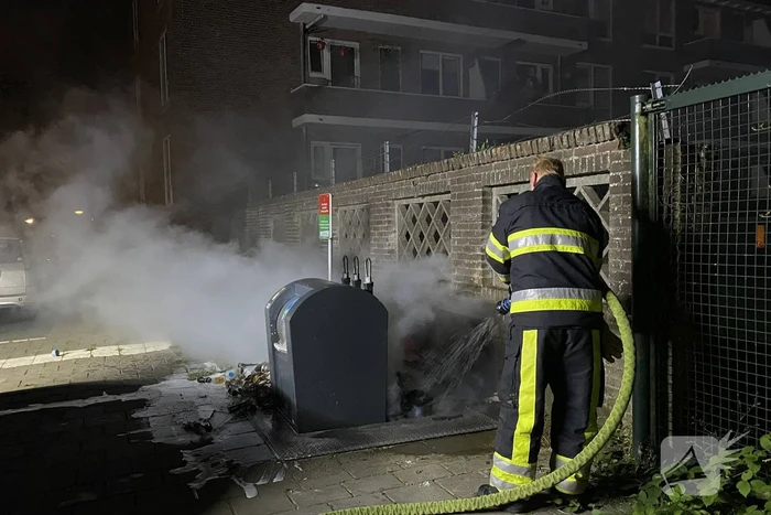 Brandweer blust brand bij container