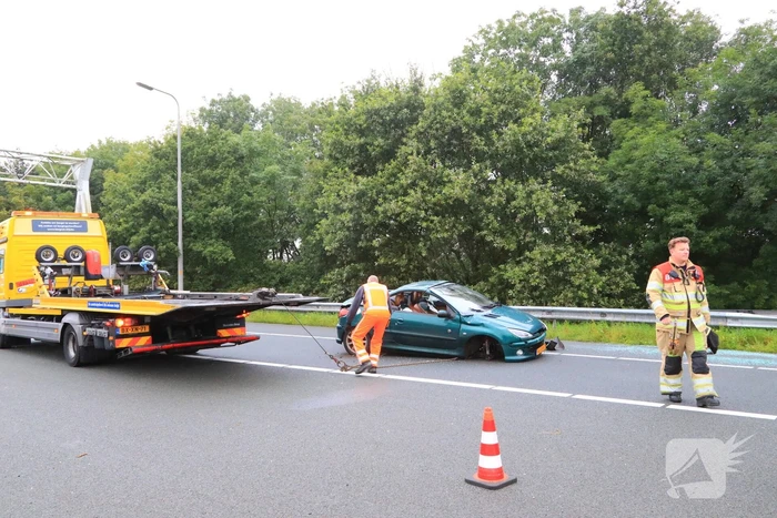 Auto glijdt over vangrail heen en belandt op zijn kop