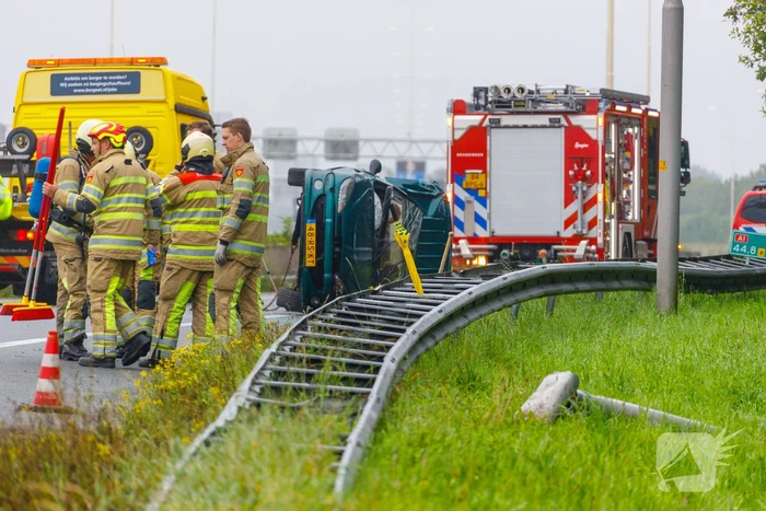 Auto glijdt over vangrail heen en belandt op zijn kop