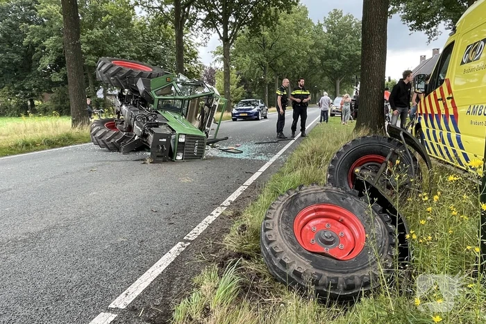 Tractor over de kop na botsing met boom