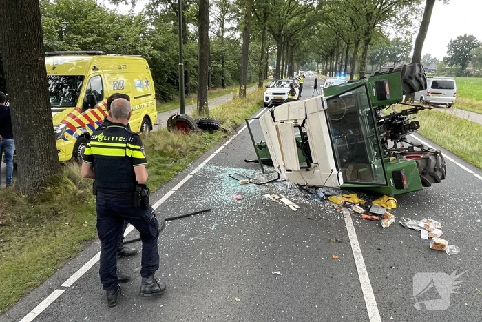 Tractor over de kop na botsing met boom