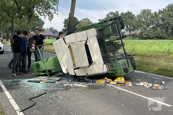 Tractor over de kop na botsing met boom