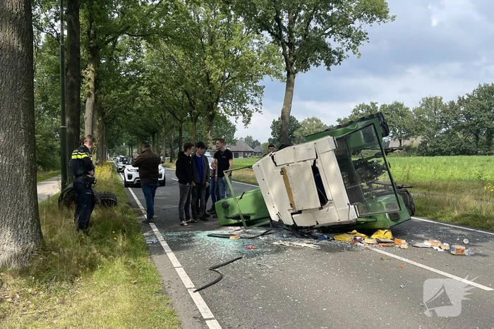 Tractor over de kop na botsing met boom