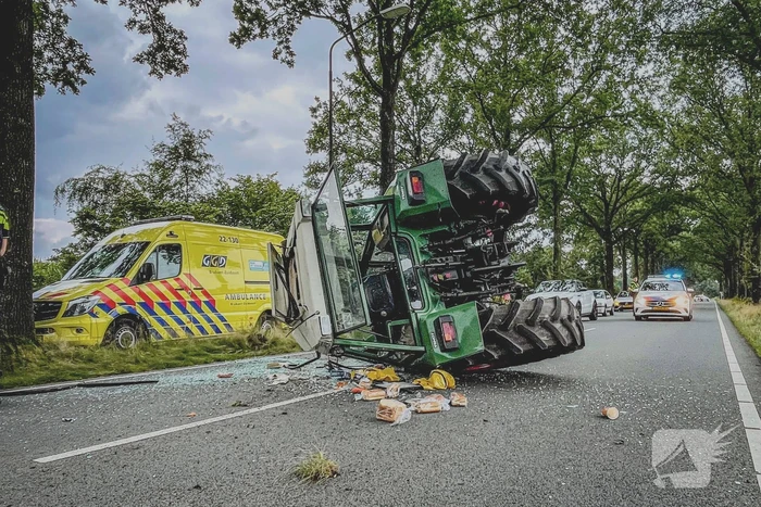 Tractor over de kop na botsing met boom