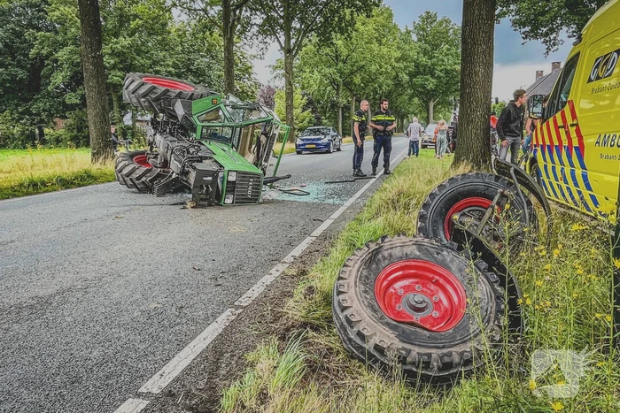 Tractor over de kop na botsing met boom