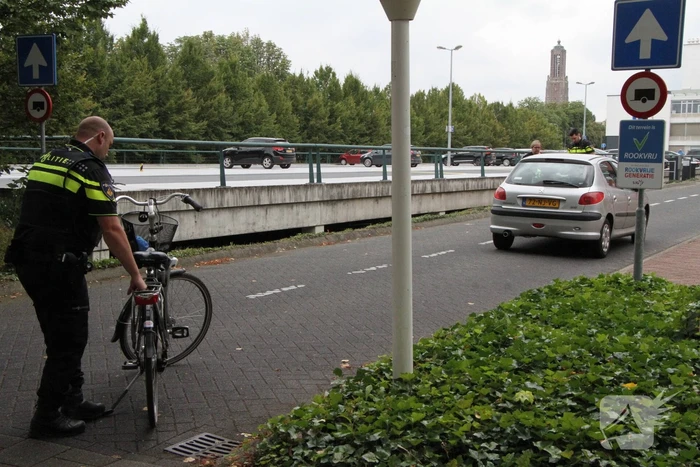 Vrouw met fiets gaat onderuit voor ingang ziekenhuis