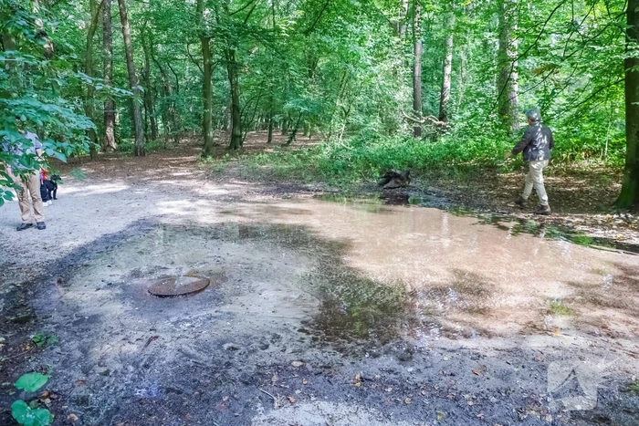 Putdeksel komt omhoog en zorgt voor wateroverlast op bospad