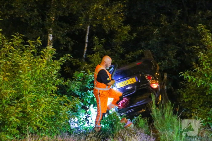 Personenauto belandt ondersteboven in bosschage